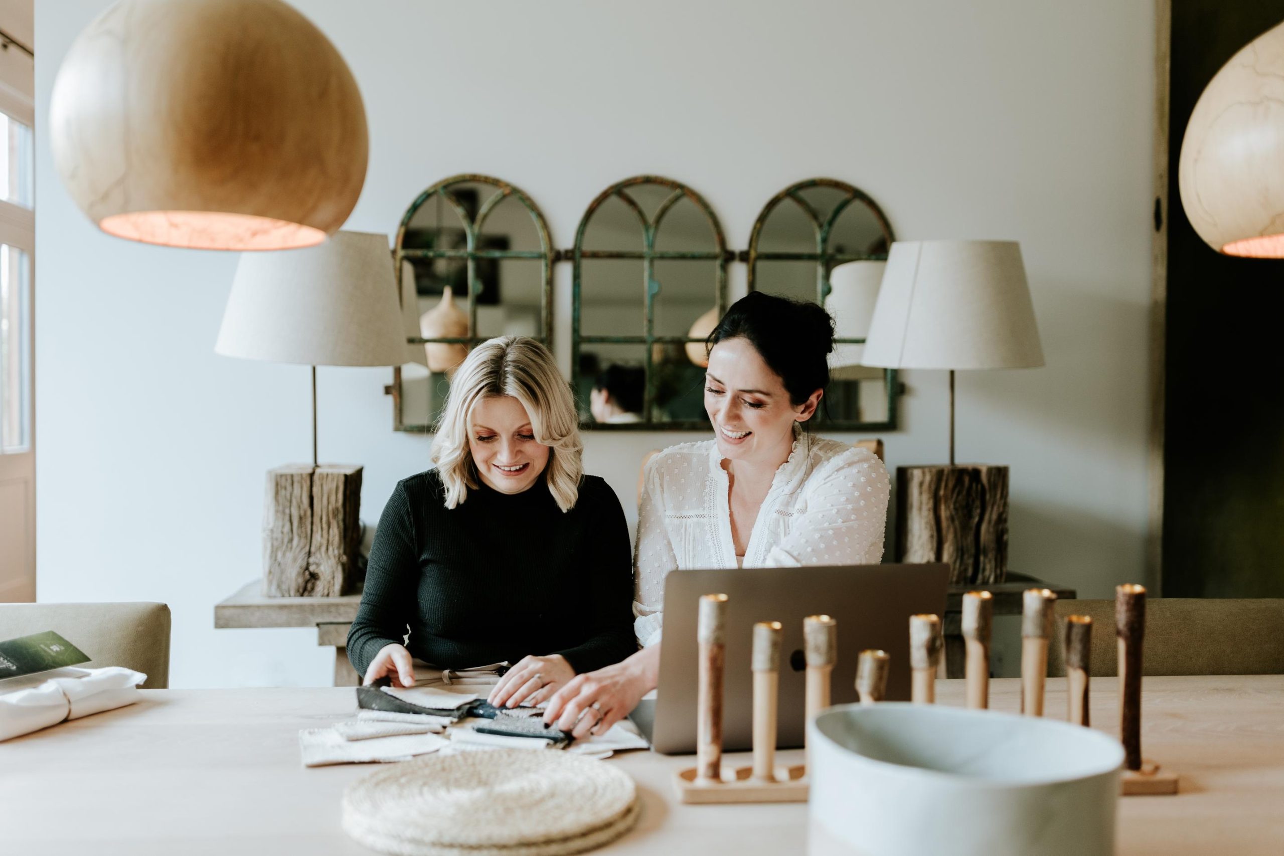 Wells and Maguire Interior Design Team sat at table, looking at swatches.