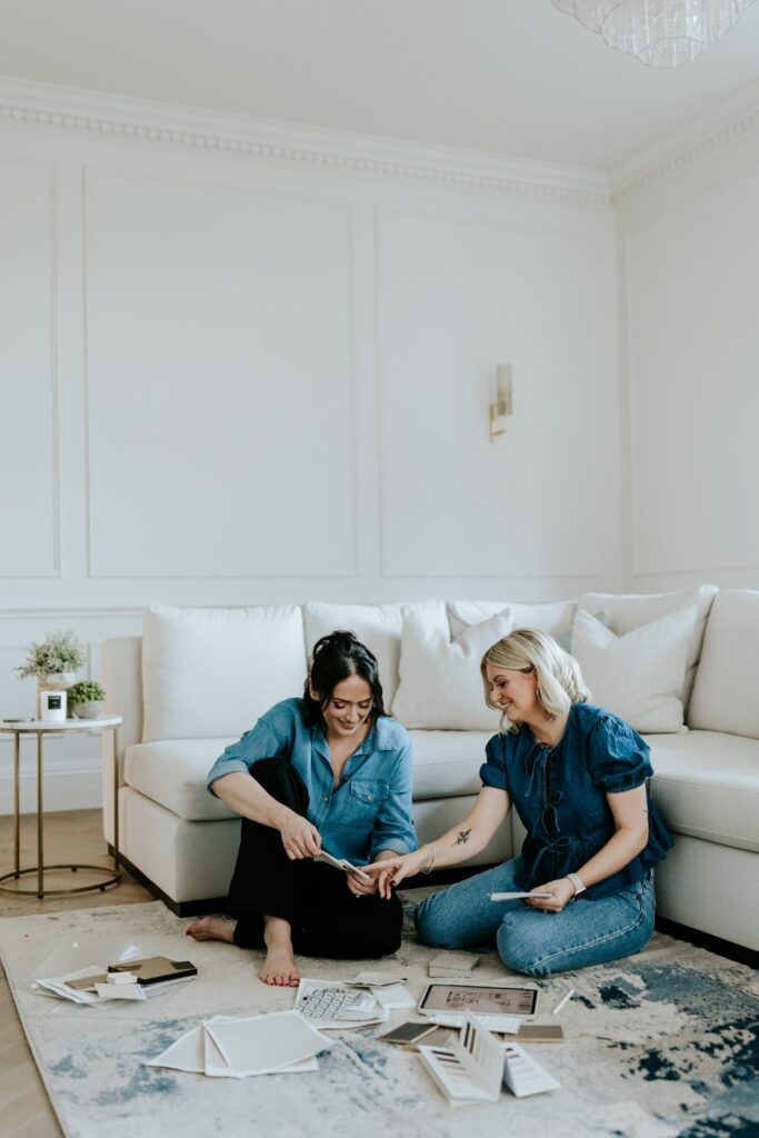 wells and maguire portrait shot of the team sitting on rug of lounge working through swatches