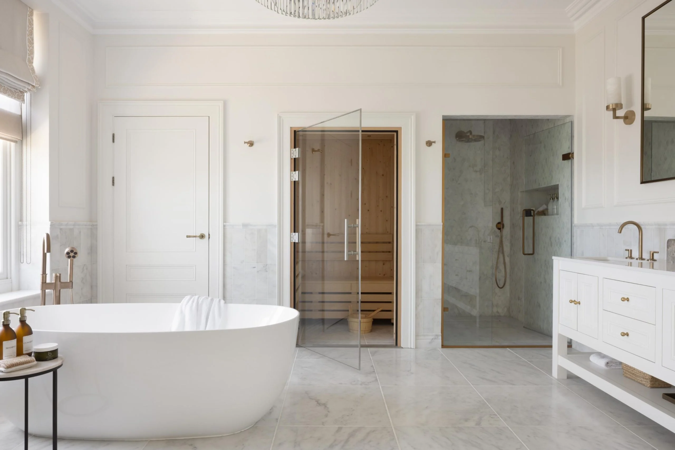 Interior designed bathroom with stand alone bath and clear door to a sauna.