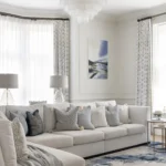 Restored Victorian living room in South Wales featuring original ornate cornicing, a period fireplace, and contemporary furnishings by Wells and Maguire.
