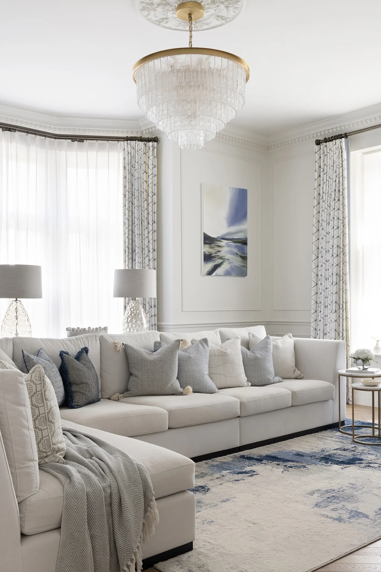Restored Victorian living room in South Wales featuring original ornate cornicing, a period fireplace, and contemporary furnishings by Wells and Maguire.